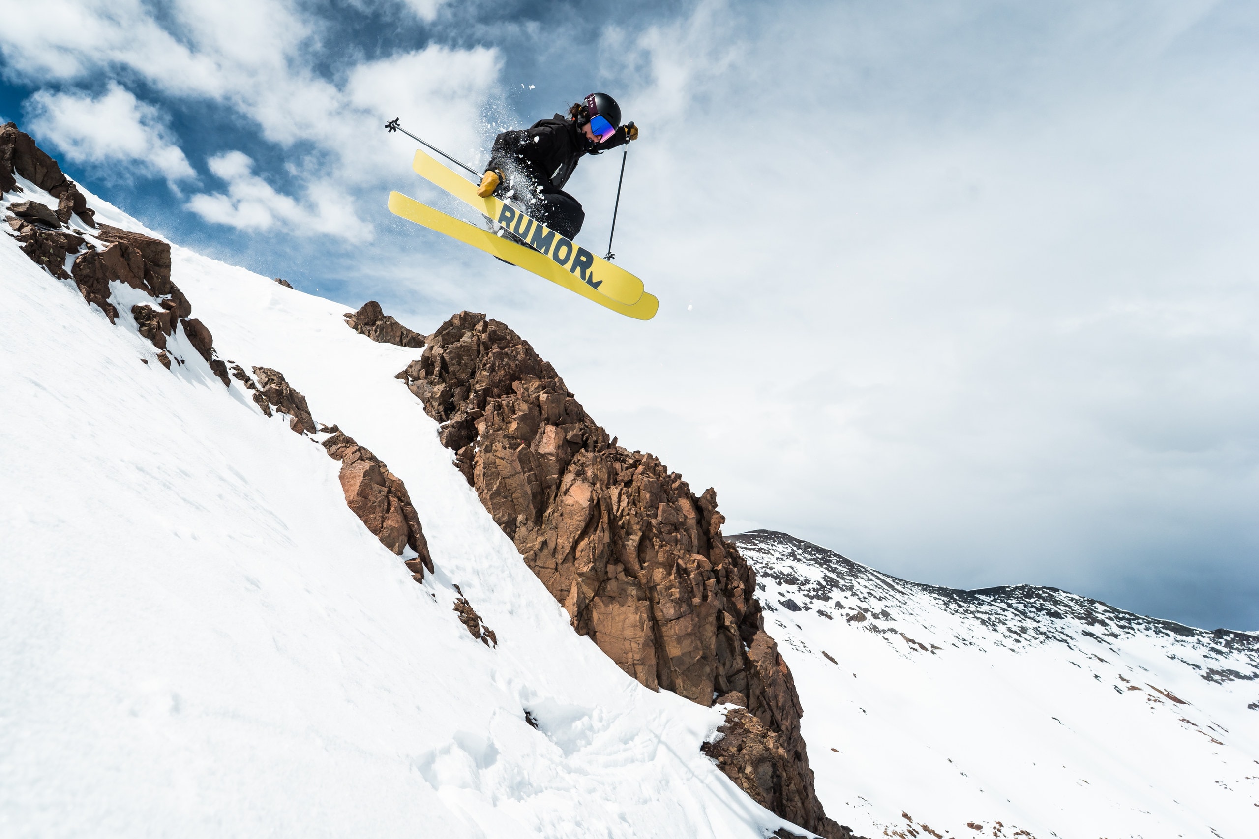 A skier airborne off a rock band