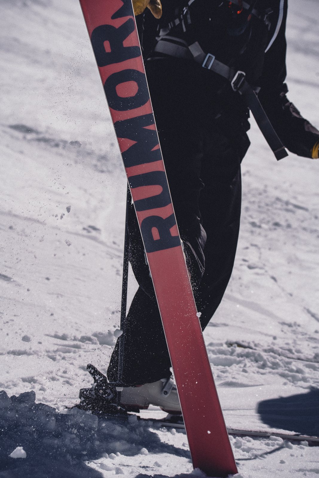 A skier carrying a REDACTED ski up the hill